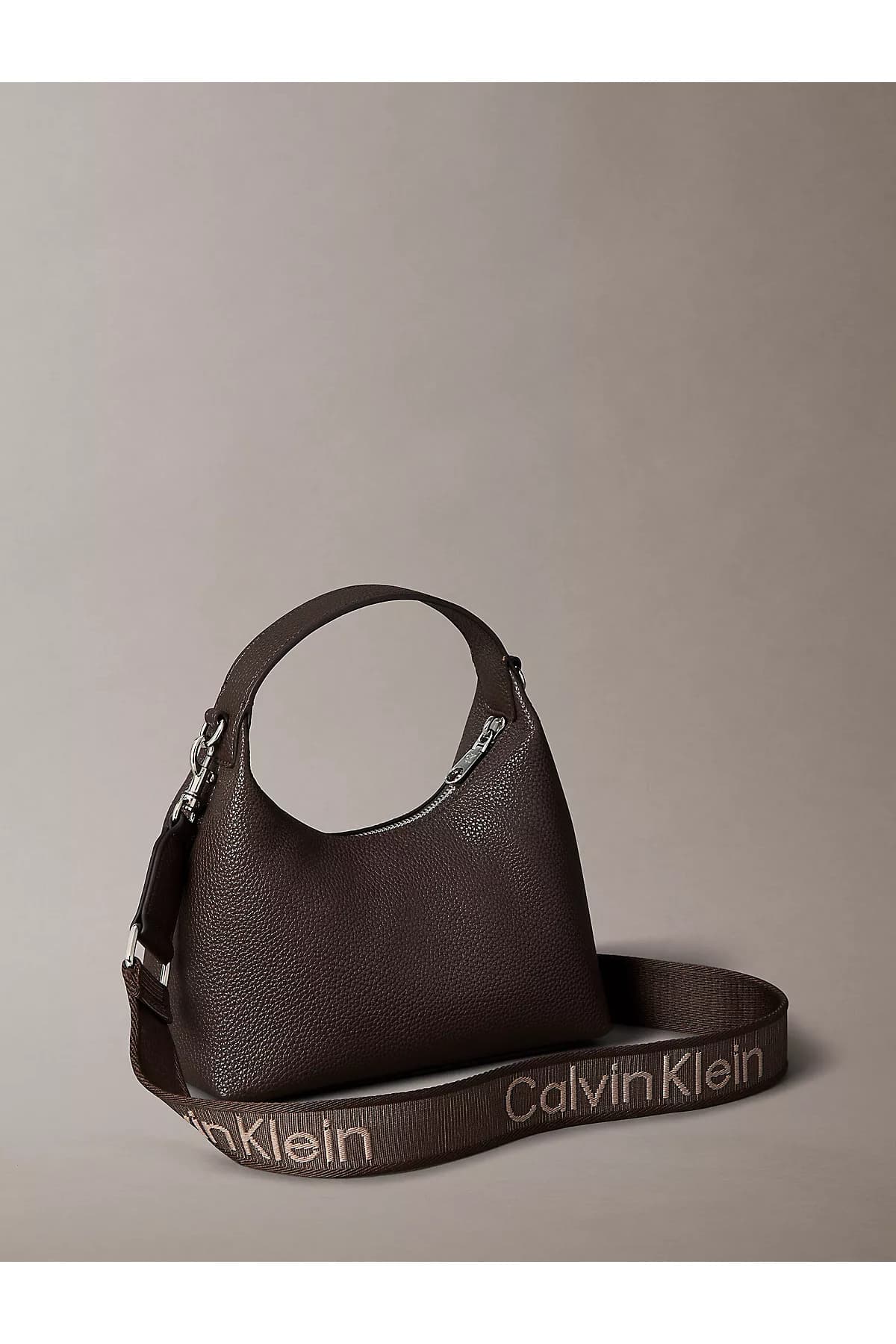 کیف زنانه Calvin Klein چرمی بند دوشی با لوگو CK قهوهای کیف زنانه Calvin Klein چرمی بند دوشی با لوگو CK قهوهای